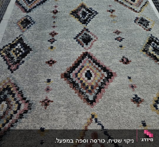 שטיח צבעוני על רשת ניקוי עם דוגמאות גיאומטריות